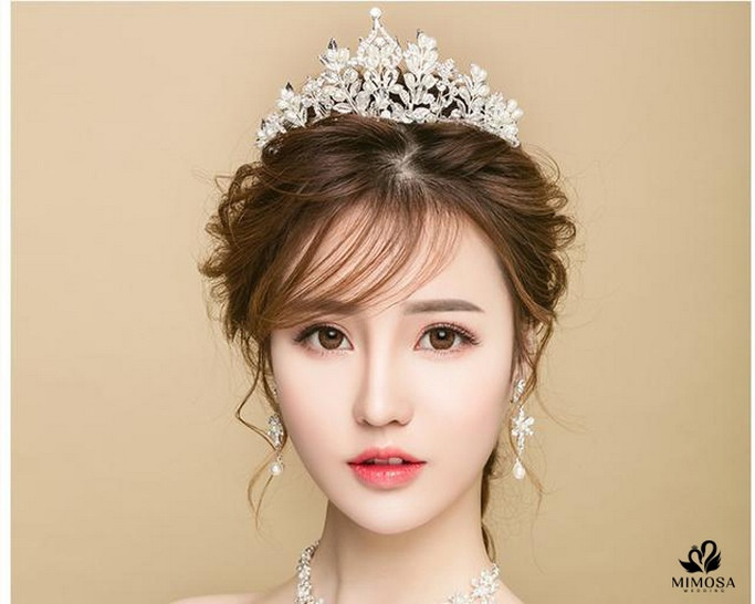 Cô dâu hiện đại với kiểu tóc búi rối kết hợp vương miện, tạo vẻ ngoài kiêu sa cho cô dâu tóc ngắn cá tính.