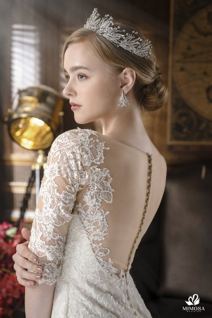 Cô dâu khoe vẻ đẹp sang trọng với tóc búi thấp và vương miện đính đá, phù hợp cho mái tóc bob tinh tế.