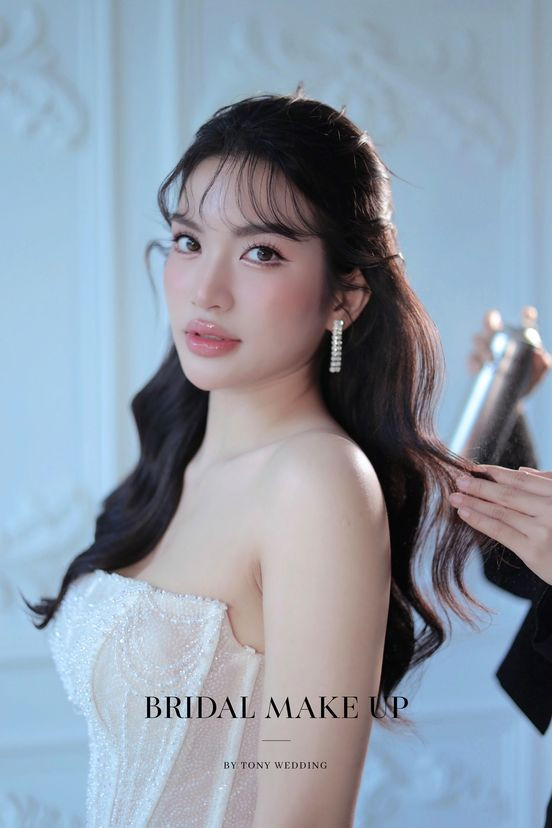 Cô dâu lãng mạn với kiểu tóc nửa búi xõa xoăn, cài hoa trắng nhẹ nhàng