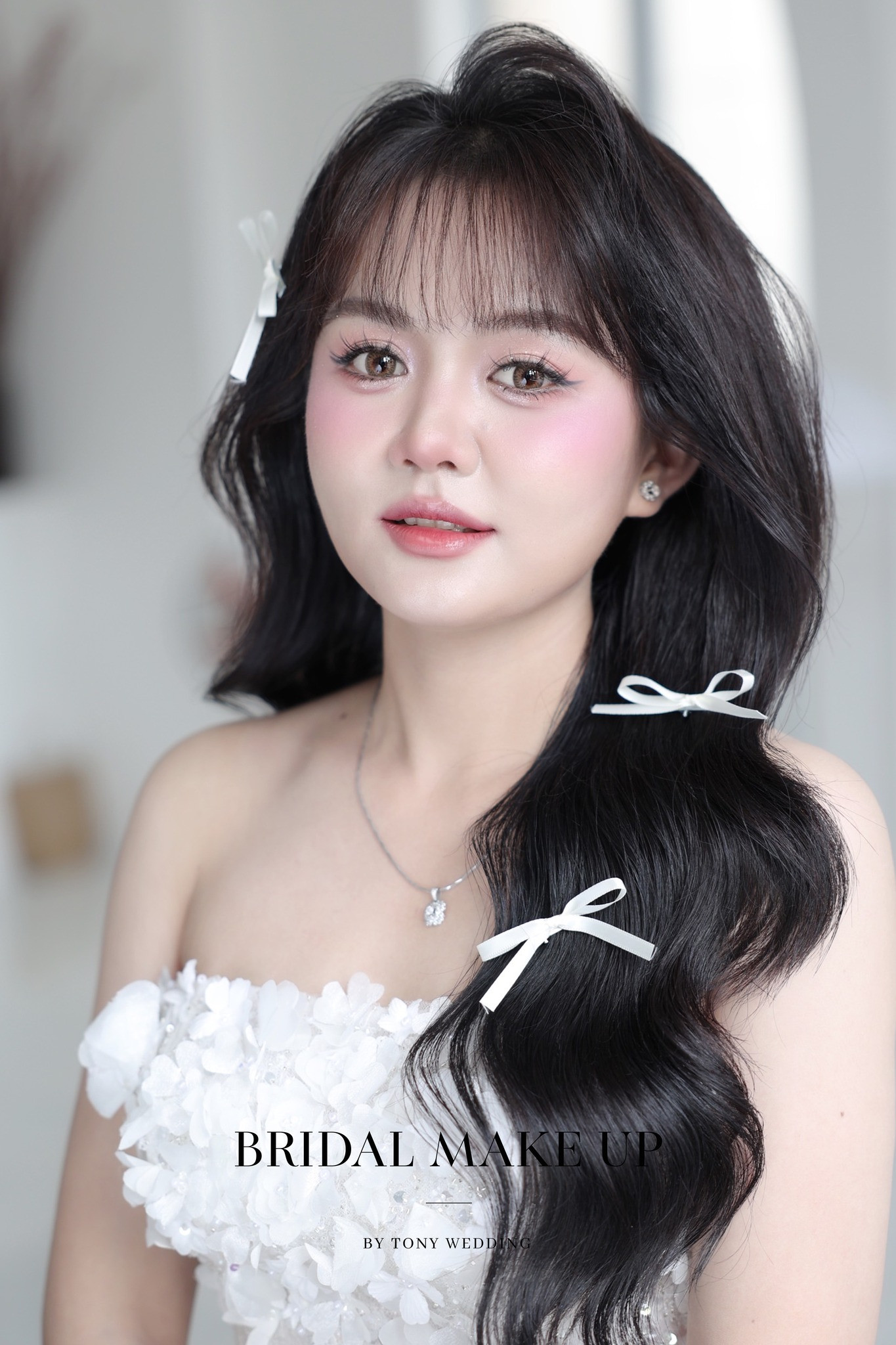 Cô dâu mặt đầy đặn rạng ngời với kiểu tóc búi cao đánh phồng, mái thưa thanh thoát