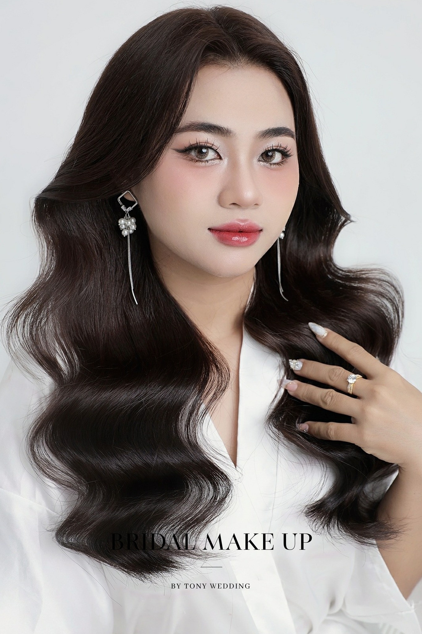 Cô dâu mặt tròn rạng ngời với kiểu tóc búi cao đánh phồng, tạo hiệu ứng thon gọn