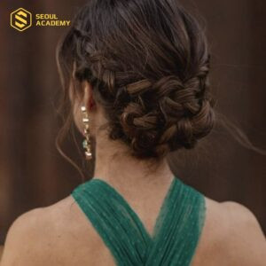 Cô dâu rạng rỡ với kiểu tóc thắt bím vòng búi sau đầu, điểm xuyết hoa tươi.