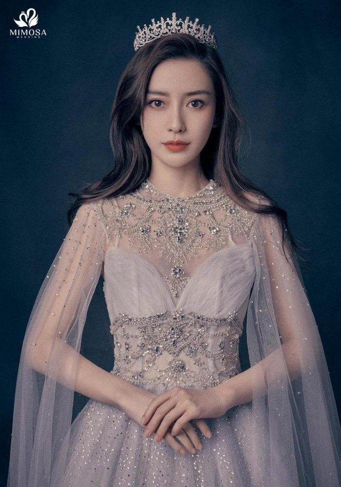 Cô dâu rạng rỡ với mái tóc dài uốn sóng bồng bềnh và vương miện, nguồn cảm hứng cho kiểu tóc bob xoăn của cô dâu tóc ngắn.