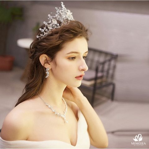 Cô dâu với kiểu tóc búi thấp thanh lịch và vương miện lấp lánh, một lựa chọn tuyệt vời cho cô dâu tóc ngắn ngang vai.