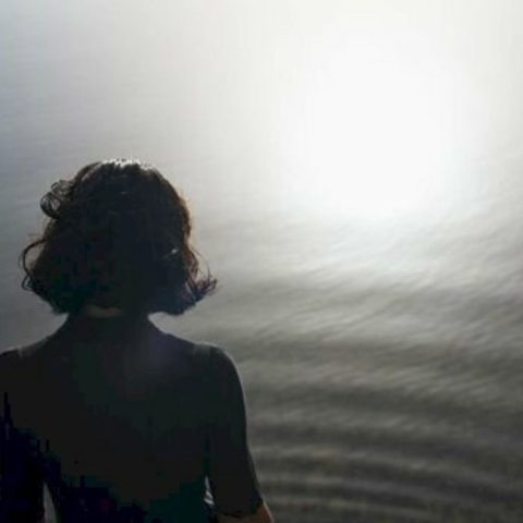 Cô gái tóc ngắn đứng nhìn ra biển