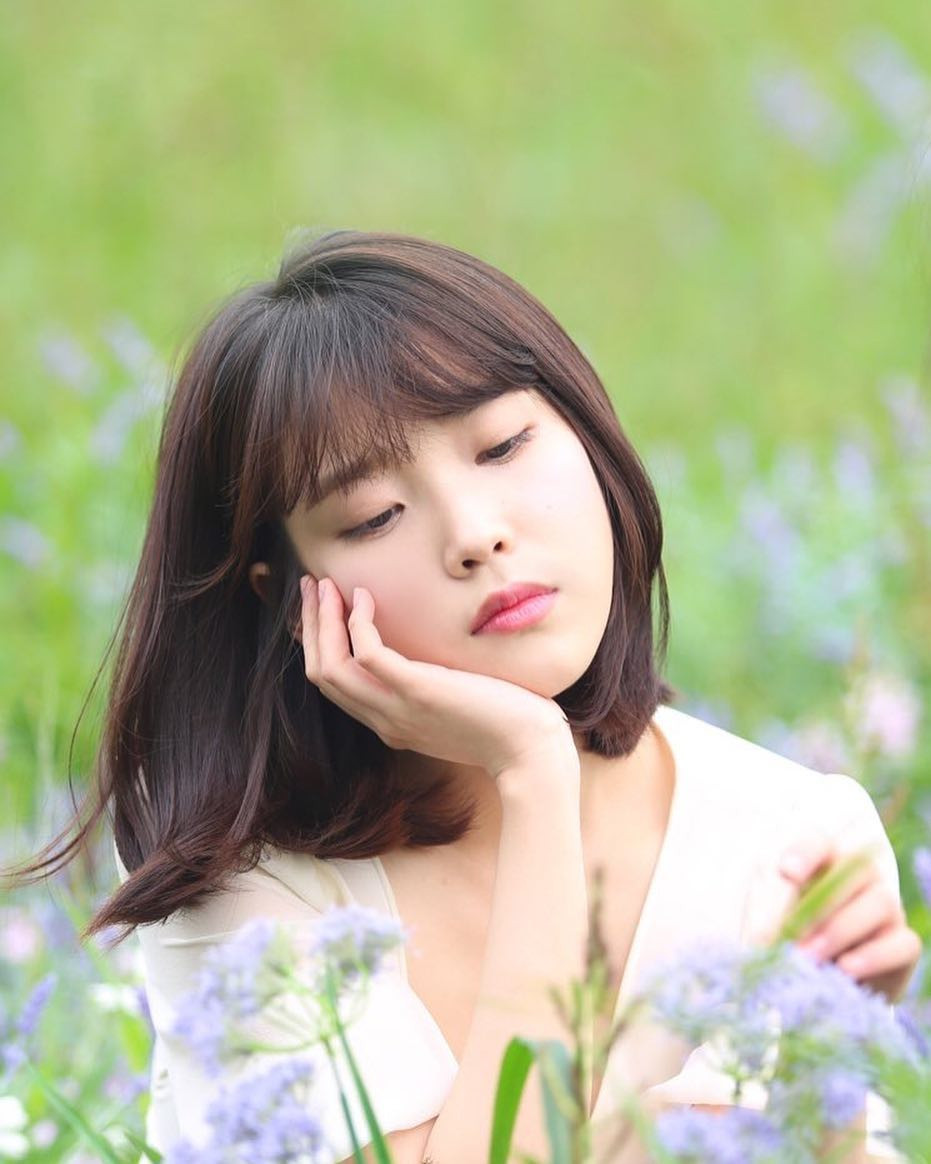 Cô gái với kiểu tóc ngắn ngang vai uốn cụp dịu dàng hợp với áo trễ vai