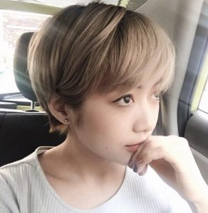 Cô gái với mái tóc bob ngắn tém cá tính, phần mái dài phủ nhẹ qua mặt, tạo vẻ bí ẩn và sành điệu trong bức ảnh nữ che mặt tóc ngắn.