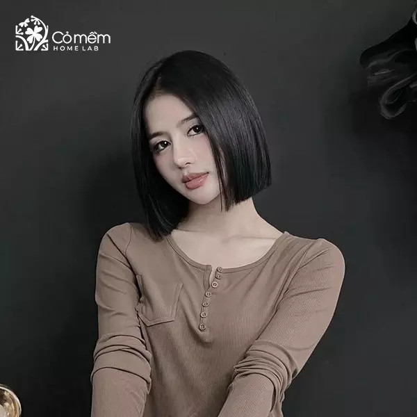 Cô gái với mái tóc ngắn duỗi cúp, màu nâu trầm, ôm sát khuôn mặt vuông tạo vẻ dịu dàng