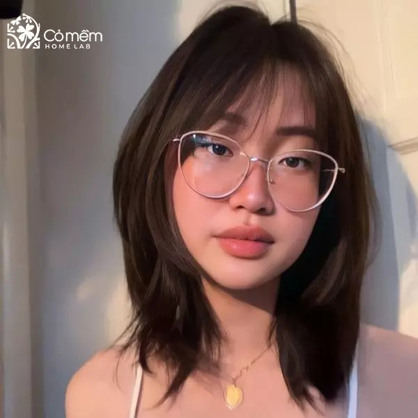 Cô gái với mái tóc ngắn mái dài rẽ ngôi, màu nâu trầm, giúp làm thon gọn khuôn mặt vuông