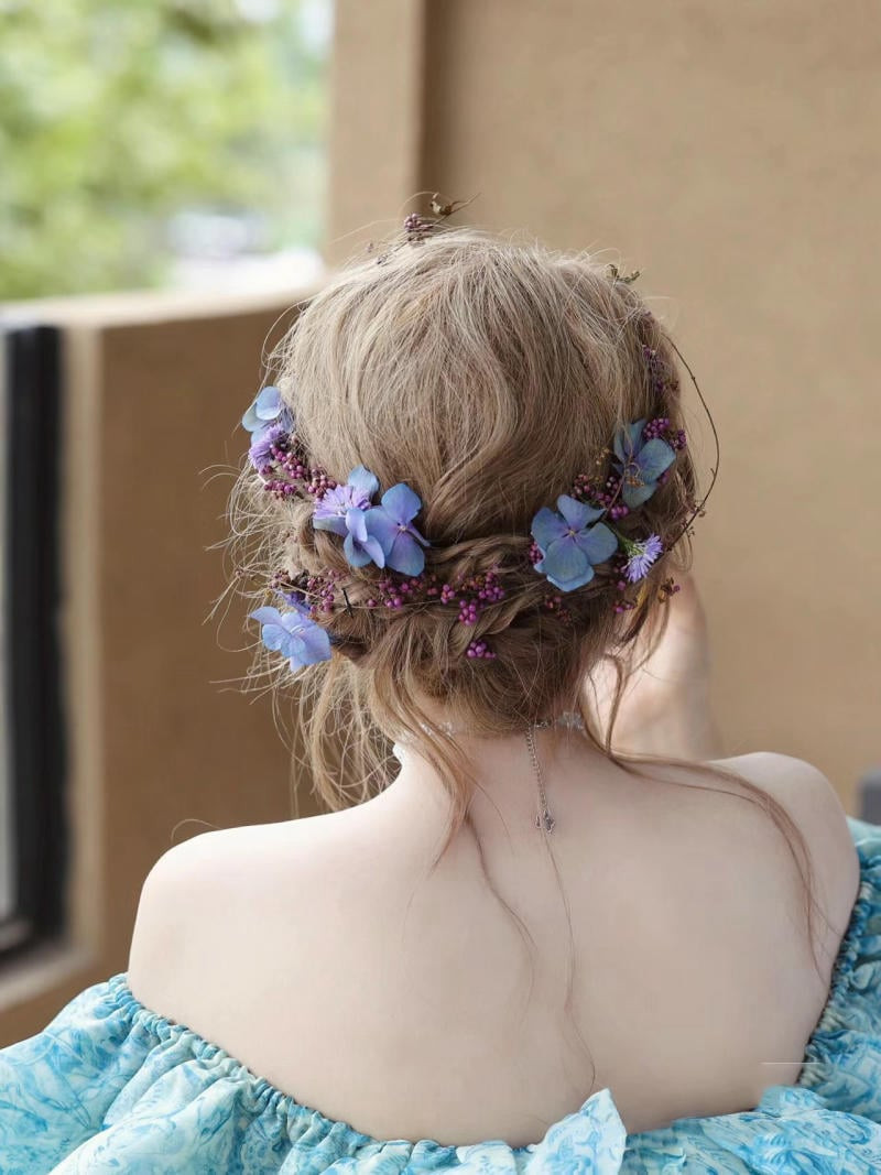 Cô gái với mái tóc tết búi thấp phía sau gáy, đính ngọc trai tinh xảo