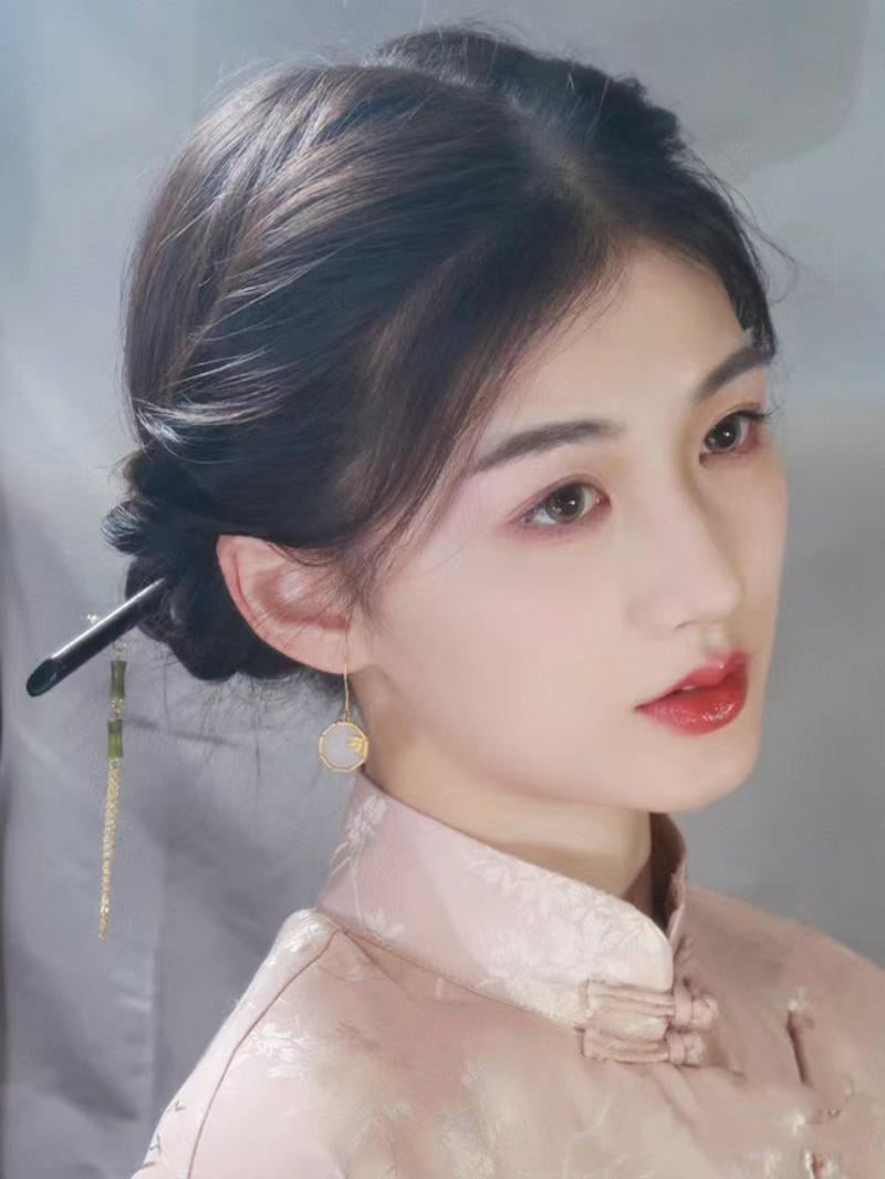 Cô gái với tóc búi gọn gàng phía sau, cài trâm hoa kim loại tinh tế