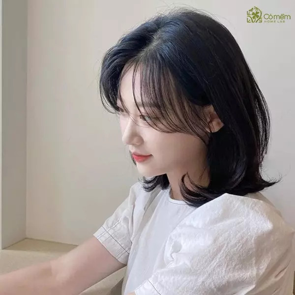 Cô gái với tóc ngắn uốn sóng lọn to, màu nâu, giúp tạo độ phồng và làm mềm các đường nét mặt vuông