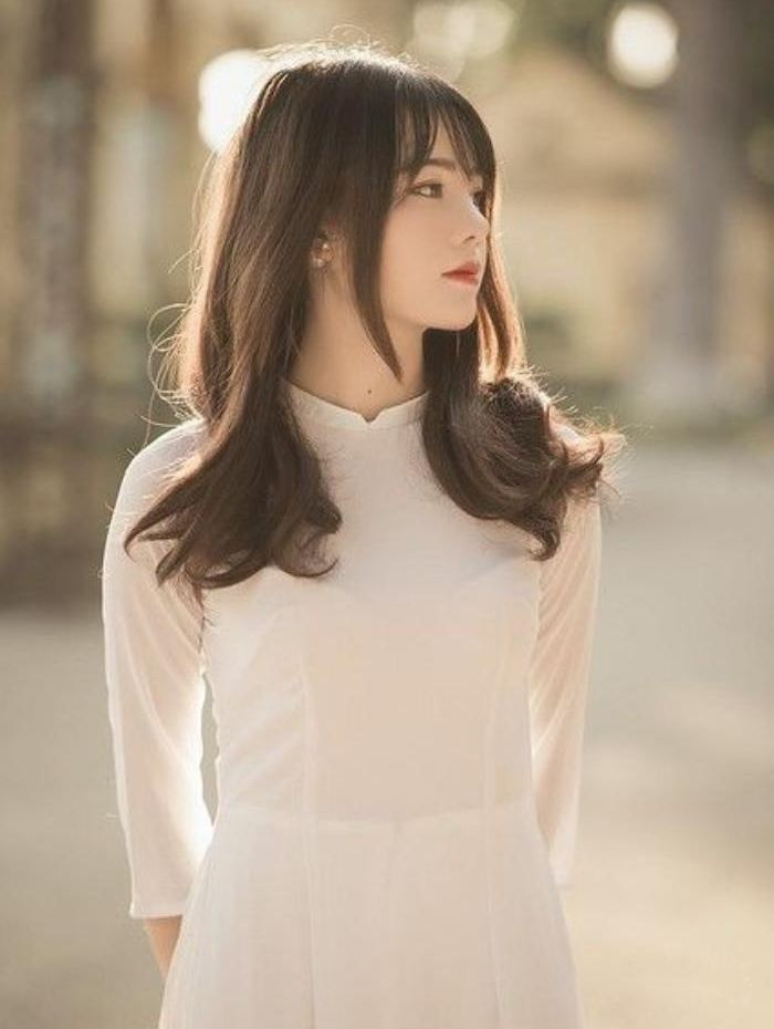 Kiểu tóc layer uốn đuôi trẻ trung kết hợp áo dài trắng