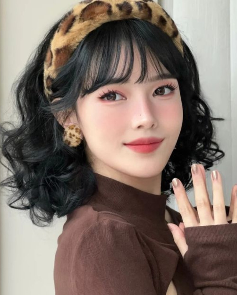 Kiểu tóc ngắn layer xoăn nhẹ kết hợp mái thưa cho gương mặt dài thêm hài hòa.