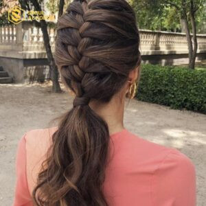 Kiểu tóc thắt bím buộc thấp kết hợp uốn nhẹ, mang lại vẻ đẹp thanh lịch cho buổi tiệc.