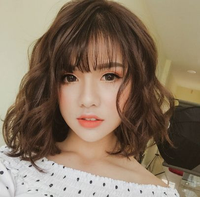Kiểu tóc xoăn lơi ngắn dễ thương với những lọn sóng mềm mại, tạo vẻ ngoài thanh lịch và quyến rũ, phù hợp cho nhiều phong cách.