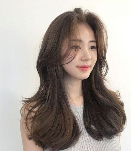 Mái tóc dài tỉa tầng ôm gọn khuôn mặt, tạo cảm giác khuôn mặt vuông tròn trở nên thon gọn và duyên dáng.