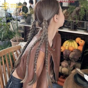 Mái tóc tết nhiều bím nhỏ buộc gọn, tạo phong cách trẻ trung, độc đáo.