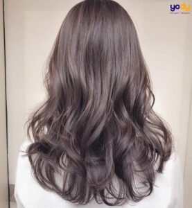 Mái tóc uốn đuôi gợn sóng nhẹ nhàng, tông màu nâu trầm, tôn lên vẻ đẹp thanh lịch của kiểu tóc uốn dài.