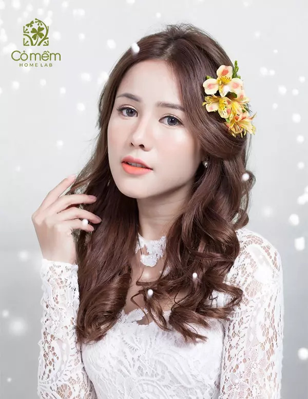 Mái tóc xoăn lọn ở phần đuôi, rẽ ngôi duyên dáng khi mặc áo dài