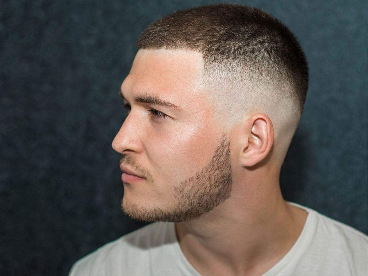 Một người đàn ông đang xem xét vẻ ngoài của mình trong gương sau khi tạo kiểu tóc quân đội Mỹ, đặt ra câu hỏi về việc sử dụng sản phẩm tạo kiểu