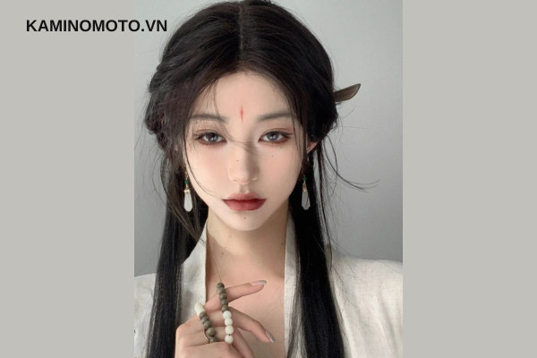 Một người phụ nữ với mái tóc búi cầu kỳ, đội mũ truyền thống, minh họa cho định nghĩa về kiểu tóc cổ trang đẹp.