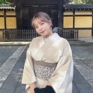 Một phụ nữ với kiểu tóc búi thấp thanh lịch và phụ kiện tóc màu trắng, nổi bật trên nền kimono màu xanh dương và trắng họa tiết truyền thống, thể hiện sự hài hòa giữa một số kiểu tóc và trang phục kimono khi dạo chơi ở Asakusa.