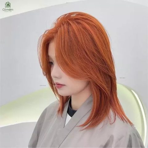 Người phụ nữ trẻ với kiểu tóc layer ngắn màu nâu hạt dẻ, phù hợp với các kiểu tóc hot 2024