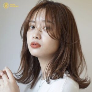 Người phụ nữ với tóc ngang vai gợn sóng mái bay bồng bềnh