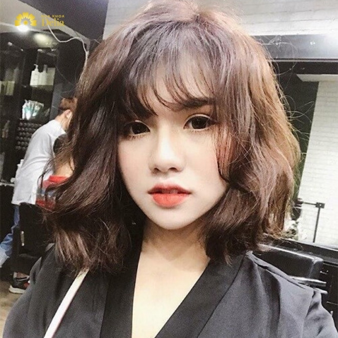 Nữ sinh với kiểu tóc mái dài ôm mặt, phù hợp cho khuôn mặt tròn trong các kiểu tóc nữ năm 2024