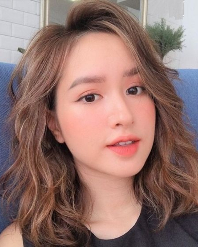 Phong cách nổi bật với tóc ngắn layer xoăn nhẹ nhuộm highlight độc đáo.