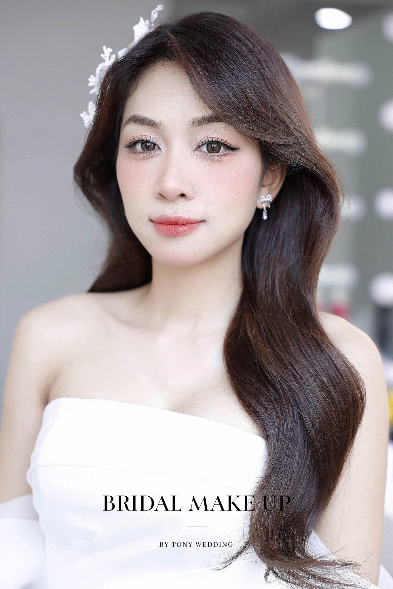 Phong cách tóc cô dâu cho mặt thon dài, búi thấp kết hợp phụ kiện hoa lụa