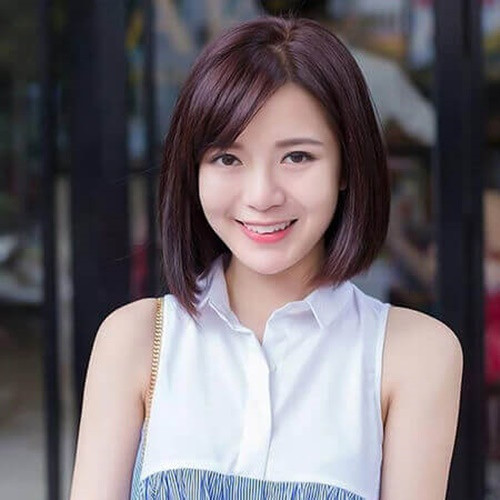 Phụ nữ trung niên với mái tóc ngắn uốn phồng và mái chéo thanh thoát