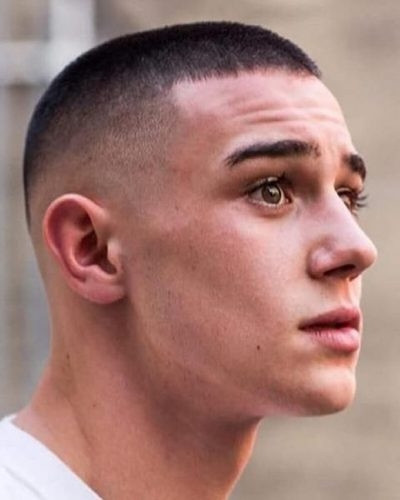 Tóc Buzz cut mạnh mẽ làm sáng gương mặt, tôn lên những đường nét nam tính của khuôn mặt vuông tròn.