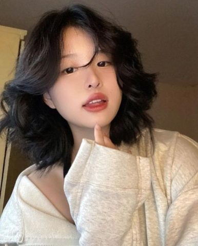 Tóc ngắn layer xoăn nhẹ phù hợp với gương mặt tròn, tạo vẻ thon gọn.