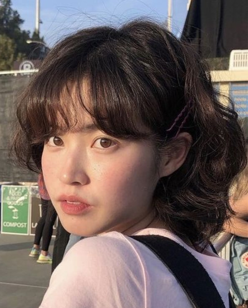 Tóc ngắn layer xoăn nhẹ tôn lên vẻ đẹp thanh tú của gương mặt trái xoan.