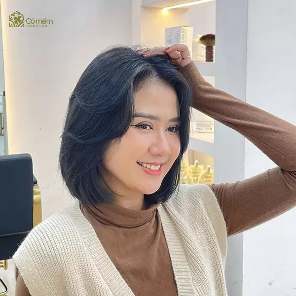 Tóc ngắn uốn chữ C, mái thưa, màu nâu trầm, giúp che khuyết điểm và tạo vẻ thanh tú cho khuôn mặt vuông