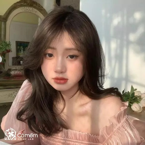Tóc ngắn uốn xoăn nhẹ ở đuôi, mái thưa, màu nâu trầm, phù hợp để làm mềm mại khuôn mặt vuông
