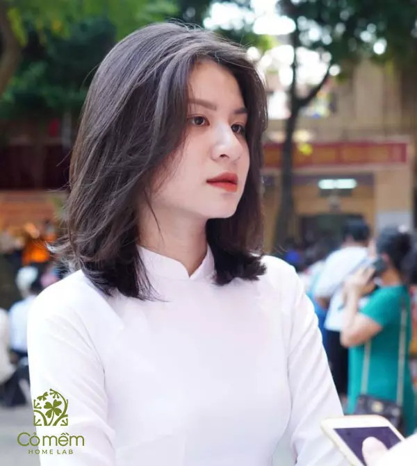 Tóc ngang vai uốn cụp đuôi tạo kiểu bồng bềnh khi mặc áo dài