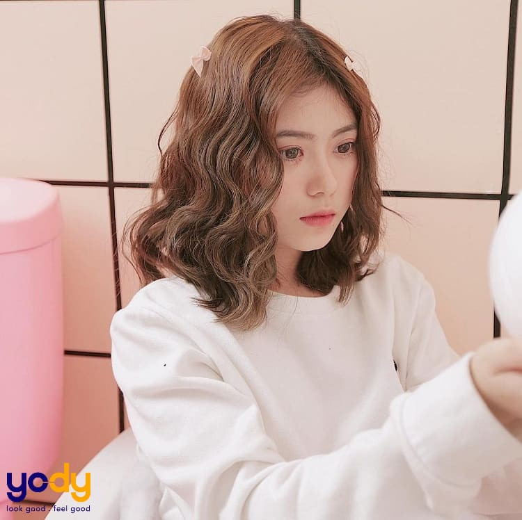 Tóc ngang vai uốn xù nhẹ nhàng, mang lại vẻ tự nhiên và hợp với mặt trái xoan
