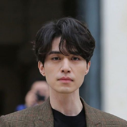 Tóc Side Part lượn sóng sang trọng tạo vẻ lịch lãm và khéo léo che đi góc cạnh cho khuôn mặt vuông tròn.
