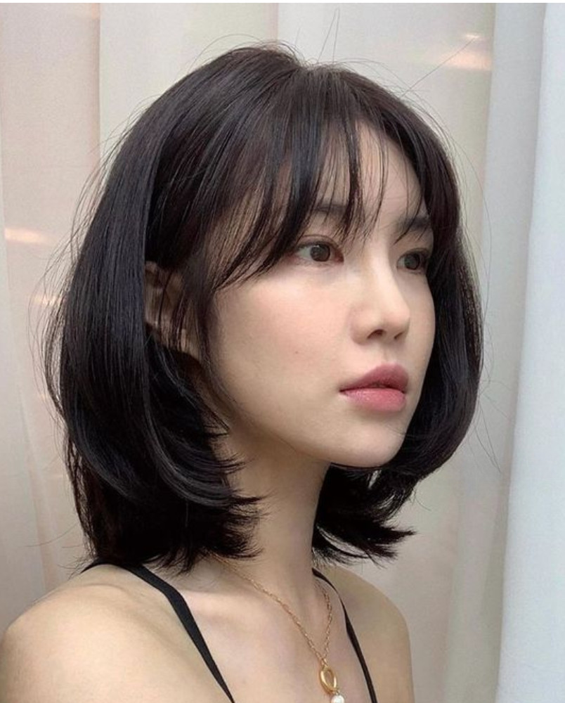 Tóc uốn cụp đuôi ngang vai, tạo độ ôm cho gương mặt dài và vẻ ngoài năng động