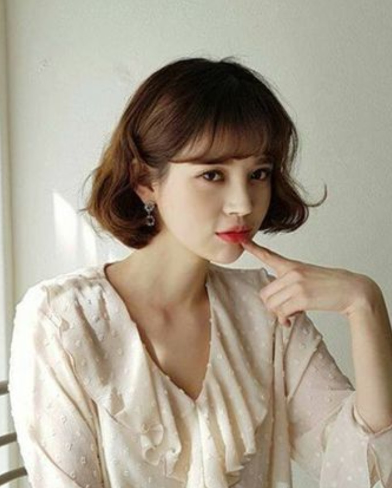 Vẻ trẻ trung với tóc ngắn layer xoăn nhẹ cùng mái bằng phù hợp mặt dài.