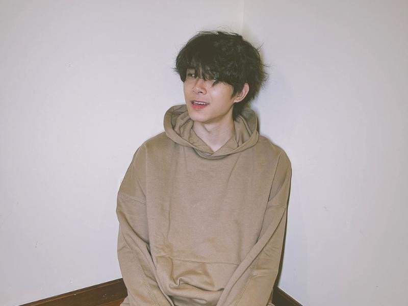 Anh Tú với kiểu tóc uốn xoăn lơi mái dài phong cách idol Hàn Quốc