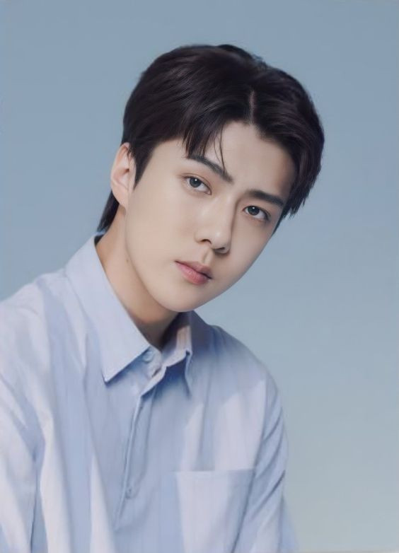 Chàng trai trẻ với mái tóc chẻ ngôi nam gọn gàng và hợp xu hướng