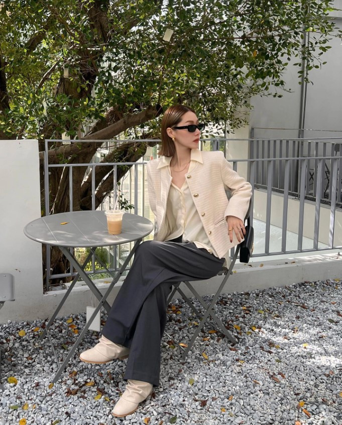 Cô gái tóc ngắn mặc áo sơ mi trắng và quần jean, tạo phong cách đơn giản và hiện đại