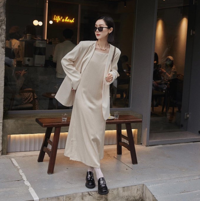Cô gái tóc ngắn mặc blazer oversize màu be và áo phông trắng, phong cách thanh lịch