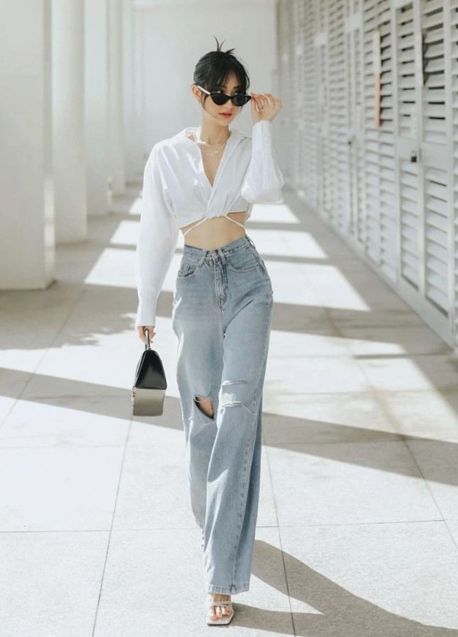 Cô gái tóc ngắn trong áo croptop trắng và quần jean ống rộng năng động