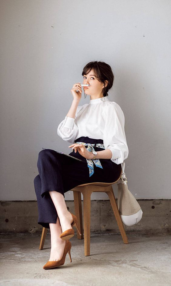 Cô gái tóc ngắn trong áo sơ mi kẻ sọc và quần tây đen, phong cách công sở lịch sự