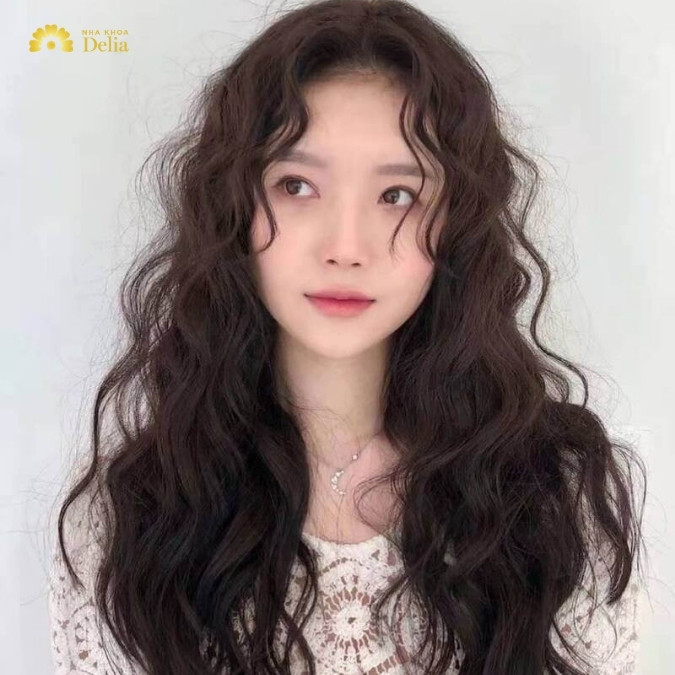 Cô gái với kiểu tóc xoăn sóng hippie cá tính, mang hơi hướng retro, một trong những kiểu tóc nữ năm 2024 nổi bật.